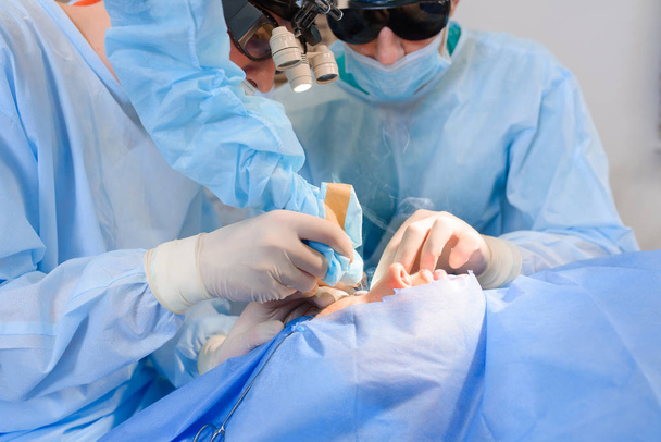 Laser blepharoplastiek, operatie van plastische chirurgie voor het corrigeren van defecten, misvormingen en disfiguraties van de oogleden; en voor het esthetisch modificeren van het ooggebied van het gezicht. in de medische kliniek - Foto, afbeelding