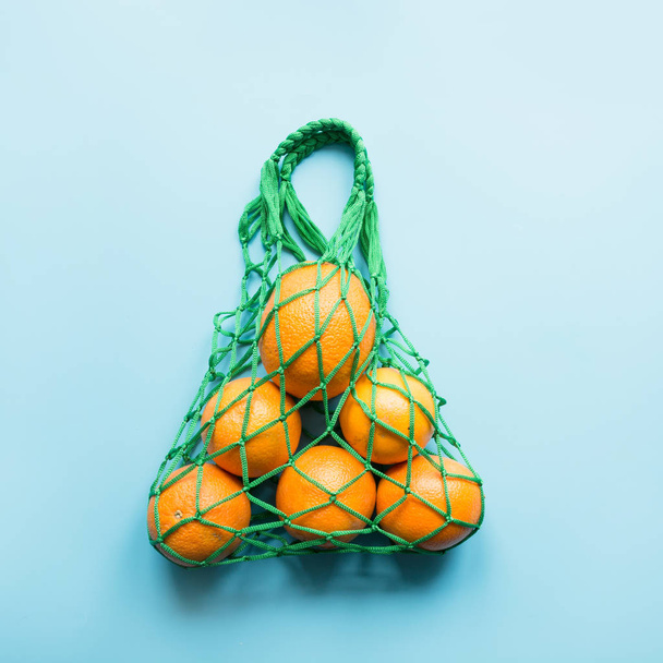 Zero waste concept. Green shopping bag with orange. Space for text. - Valokuva, kuva
