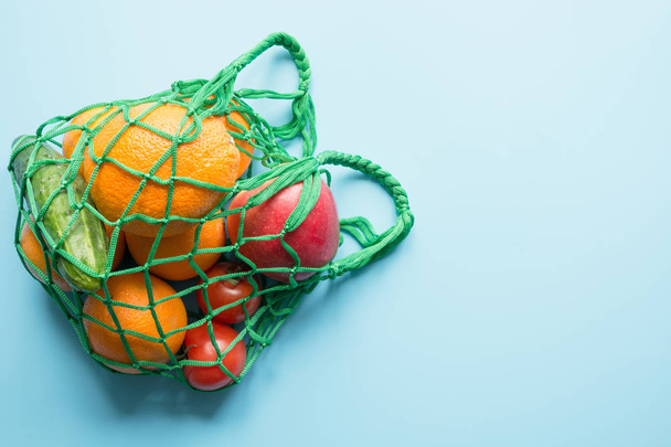 Zero waste concept. Green shopping textile bag with fresh orange and vegetables. Space for text. - Fotografie, Obrázek