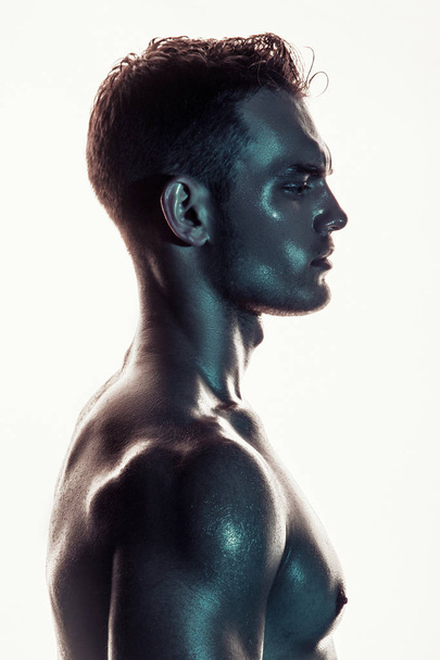 Sport sexy stripped muscle guy portrait in colored light on shine isolated white font background - Fotó, kép