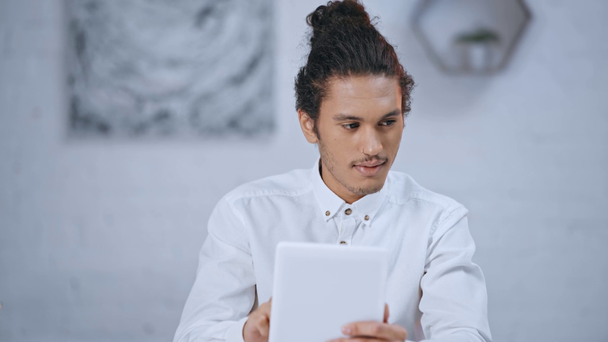 knap en knappe zakenman met behulp van digitale tablet en lachend op werkplek  - Video
