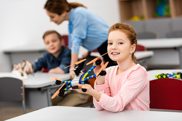 Inkivääri koulutyttö osoittaa opettavainen lelu oppitunnin aikana luokkahuoneessa
 - Valokuva, kuva