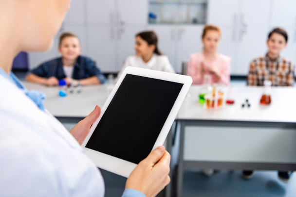 Partial view of chemistry teacher holding digital tablet with blank screen - Fotografie, Obrázek