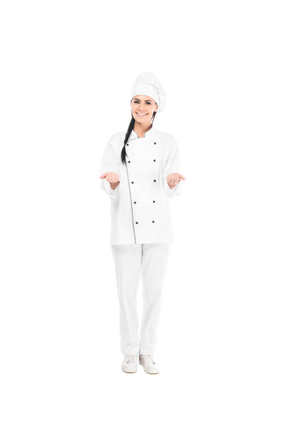 Smiling chef in hat showing shrug gesture isolated on white - Foto, imagen