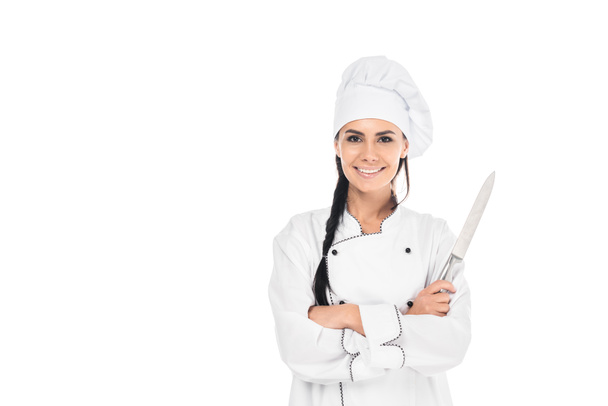 Smiling chef in uniform holding knife with crossed arms isolated on white - Fotografie, Obrázek