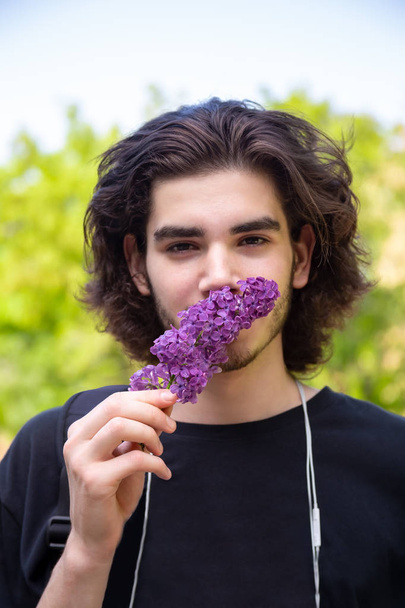 Man smelling lilac twig - Фото, изображение