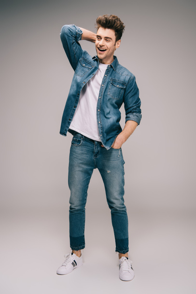 smiling and good-looking man in jeans, skirt and t-shirt with hand in pocket looking away - Foto, Imagem