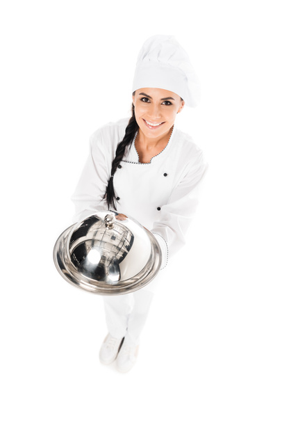 Chef in hat holding tray with cloche on white - Valokuva, kuva