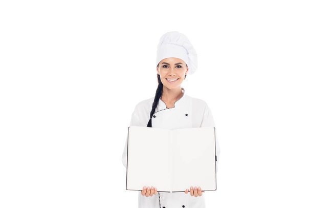 Chef sonriente con sombrero sosteniendo libro abierto aislado en blanco
 - Foto, Imagen