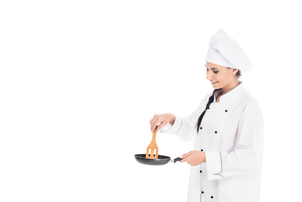 Chef-kok in de koekenpan en houten keuken spatel geïsoleerd op een witte hoed - Foto, afbeelding