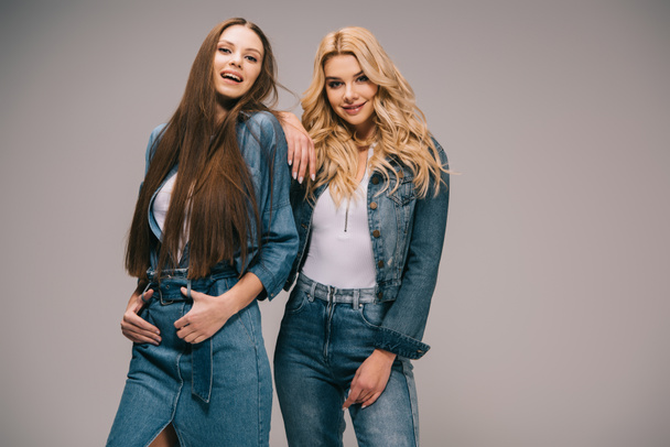 happy blonde and brunette women in denim clothes smiling and looking at camera  - Φωτογραφία, εικόνα
