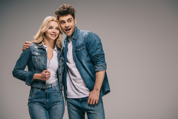 boyfriend and smiling girlfriend in denim clothes hugging and looking away  - Foto, Bild