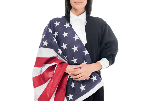 Cropped view of judge in judicial robe holding american flag isolated on white - Foto, afbeelding