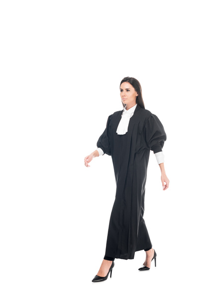 Pleine longueur vue du juge grave en robe judiciaire marche isolé sur blanc
 - Photo, image