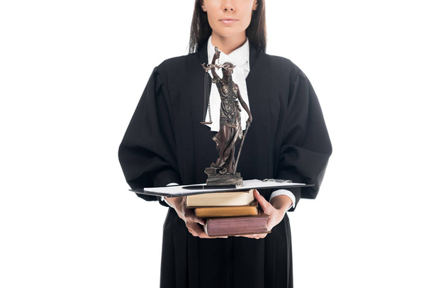 Vista recortada del juez en bata judicial sosteniendo themis estatuilla, libros y portapapeles aislados en blanco
 - Foto, Imagen