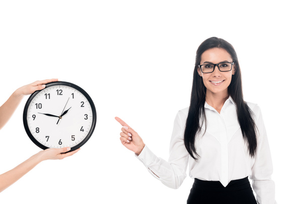 Smiling businesswoman in glasses pointing with finger at clock isolated on white - Foto, Imagen