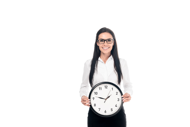 Щаслива брюнетка бізнес-леді в сорочці тримає годинник ізольовано на білому
 - Фото, зображення