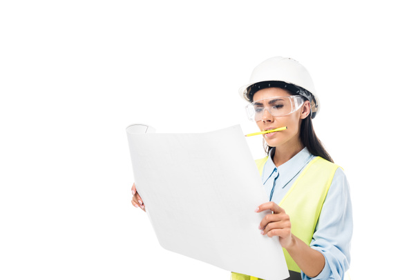 Concentrated engineer in safety vest looking at blueprint isolated on white - Photo, Image