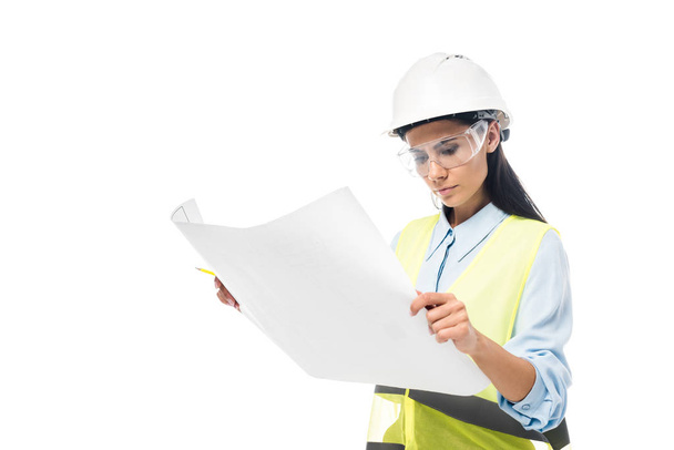 Concentrated engineer in safety vest looking at blueprint isolated on white - Photo, Image