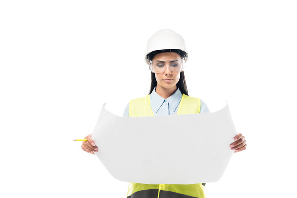 Concentrated engineer in safety vest looking at blueprint isolated on white - Fotó, kép