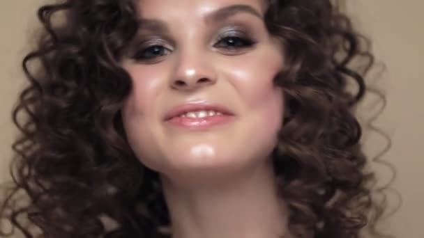 Beautiful brunette girl with a perfectly curly hair, and classic make-up posing in the studio. Beauty face. - Footage, Video