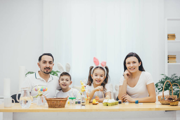 Mother, father son and daughters are ready for Easter. Cute little children wearing bunny ears. Everyone smiling. - Valokuva, kuva