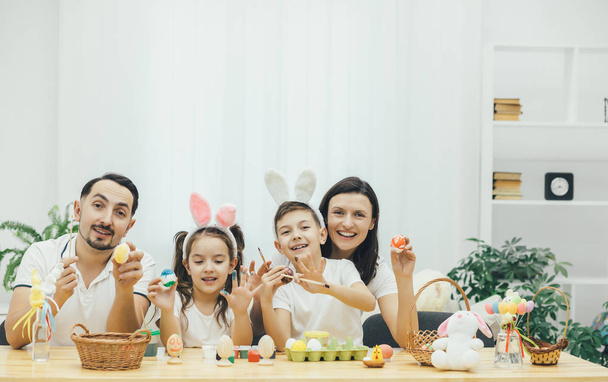 Békés anya apa fia és lánya van szó-fer húsvét, előkészítésére különböző húsvéti tojásfestés, különböző színekben, pózol a kamera. A testvérpár, valamint viselése - Fotó, kép