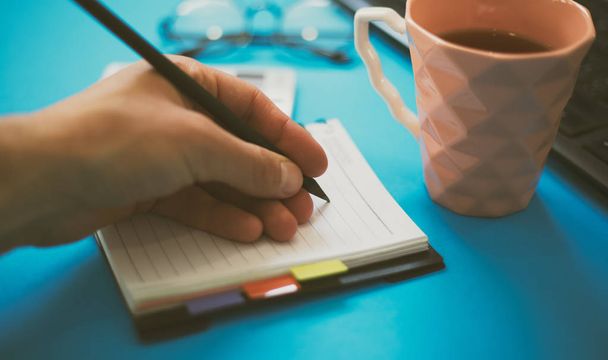Escritorio de oficina azul con bloc de notas, taza de té
. - Foto, Imagen