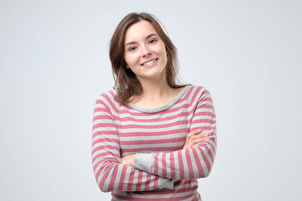 Χαμογελαστός νεαρός καυκάσιος γυναίκα με τα χέρια διπλωμένα - Φωτογραφία, εικόνα