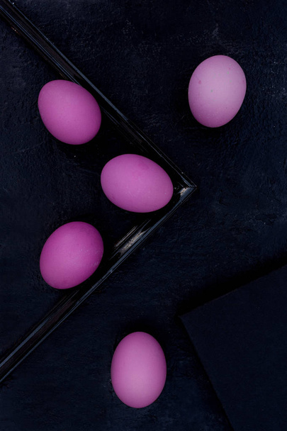 Purple Easter eggs on black background. - Foto, afbeelding
