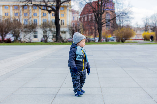 Little toddler boy stay at city street alone. - Zdjęcie, obraz