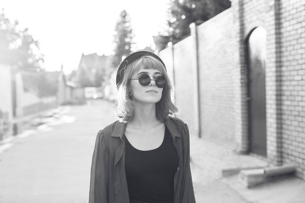 Fashionable young woman walking down the street. Black and white - Φωτογραφία, εικόνα