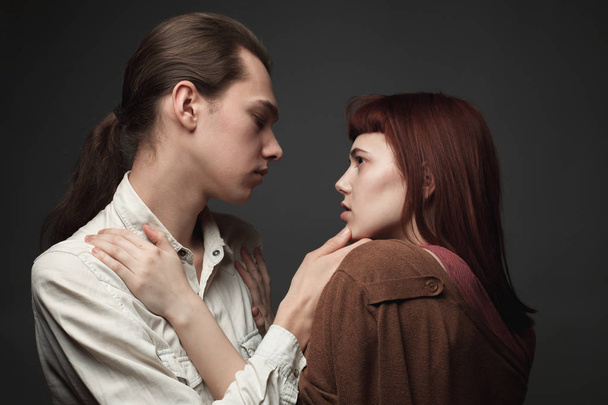 Young man and woman on the gray background. - Фото, зображення