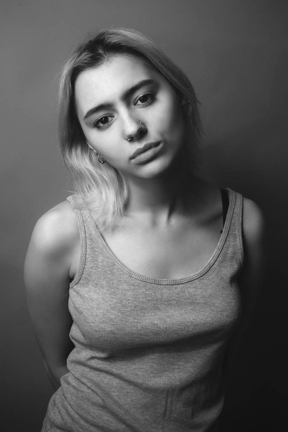 Young woman with shirt on the gray background. Black and white - Фото, зображення