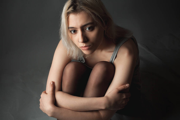 Sad young woman sitting on the floor. - Valokuva, kuva