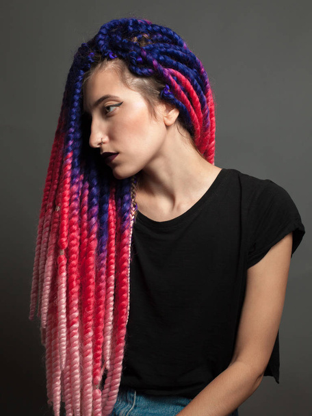 Girl with color braids in the studio. Profile - 写真・画像