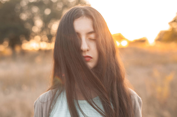 Portrait of a young woman with closed eyes outdoors - Foto, Imagen
