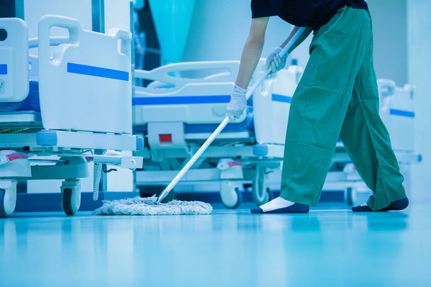 Cleaner, hospital cleaning, cleaner with mop and uniform cleaning hall floor, cleaning floor with mop in patient room, Cleaning the hospital floor
 - Фото, изображение