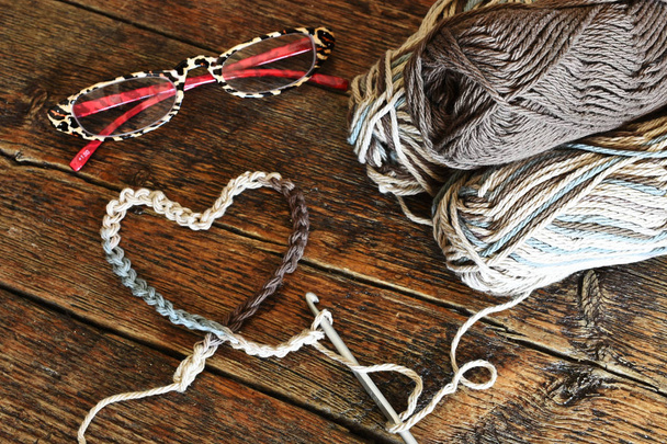 Une image rapprochée d'un crochet unique crochet et crochet fil dans un symbole en forme de coeur
. - Photo, image