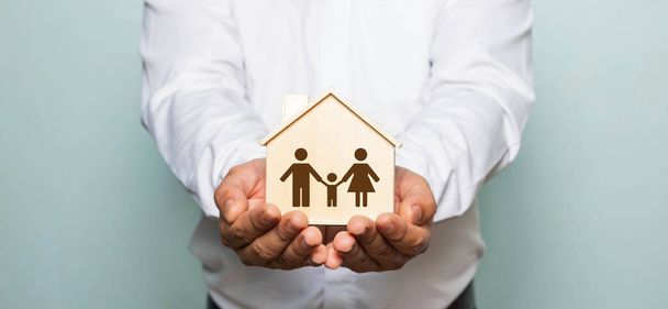 Young man holding  toy house in hands. Home insurance concept. - Photo, Image