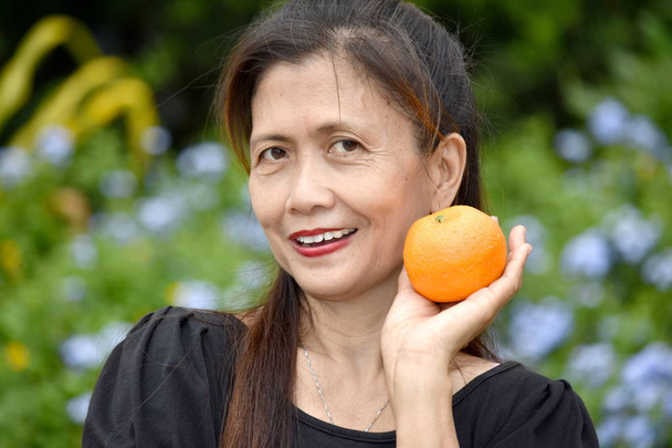 Female Senior And Happiness With An Orange - Foto, Bild