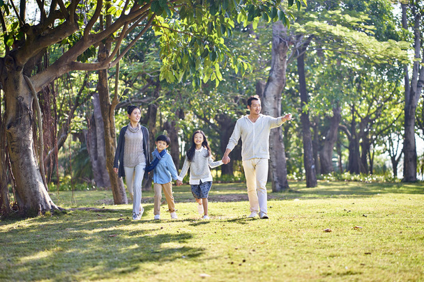 asian family with two children walking in park - Photo, Image