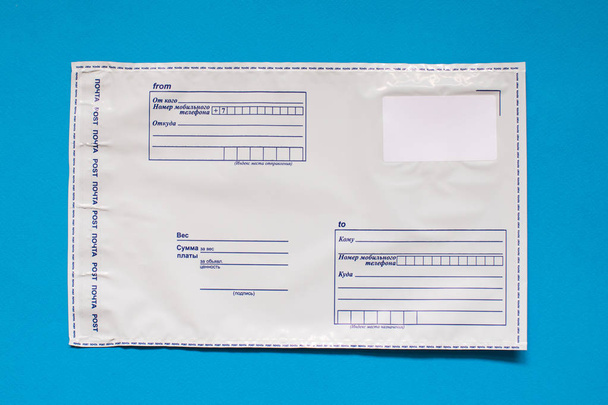 Russian post polyethylene envelope on blue background. Plastic Postal Mailing Bags - Foto, afbeelding