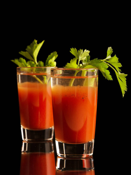 Two shots of Bloody Mary cocktail drink isolated on black background - Foto, Imagem