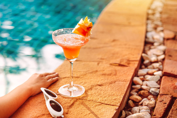 Summer Cocktail or Juice,sunglasses at swimming pool female resting in vacation in resort. - Foto, Imagen