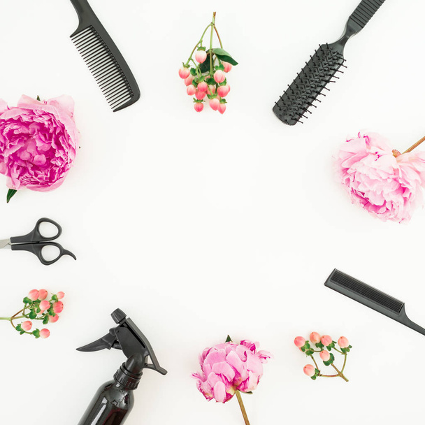 Concepto de peluquería con spray, tijeras, peines y peonías flores sobre fondo blanco. Puesta plana
 - Foto, imagen
