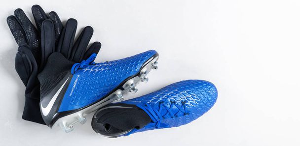 Pair of football soccers boots cleats Nike shoes and gloves on white background - Фото, изображение