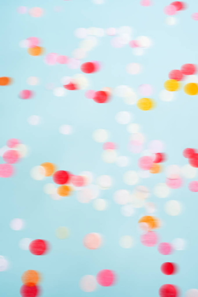 Flying moving bright confetti on blue pastel background  - Φωτογραφία, εικόνα