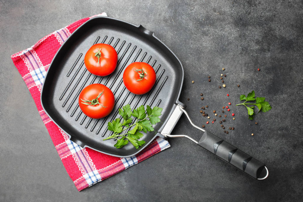 сковородка на гриле с помидорами и зеленью
  - Фото, изображение
