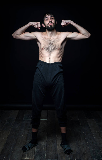 A young man in his pants on a black background - Foto, Imagem